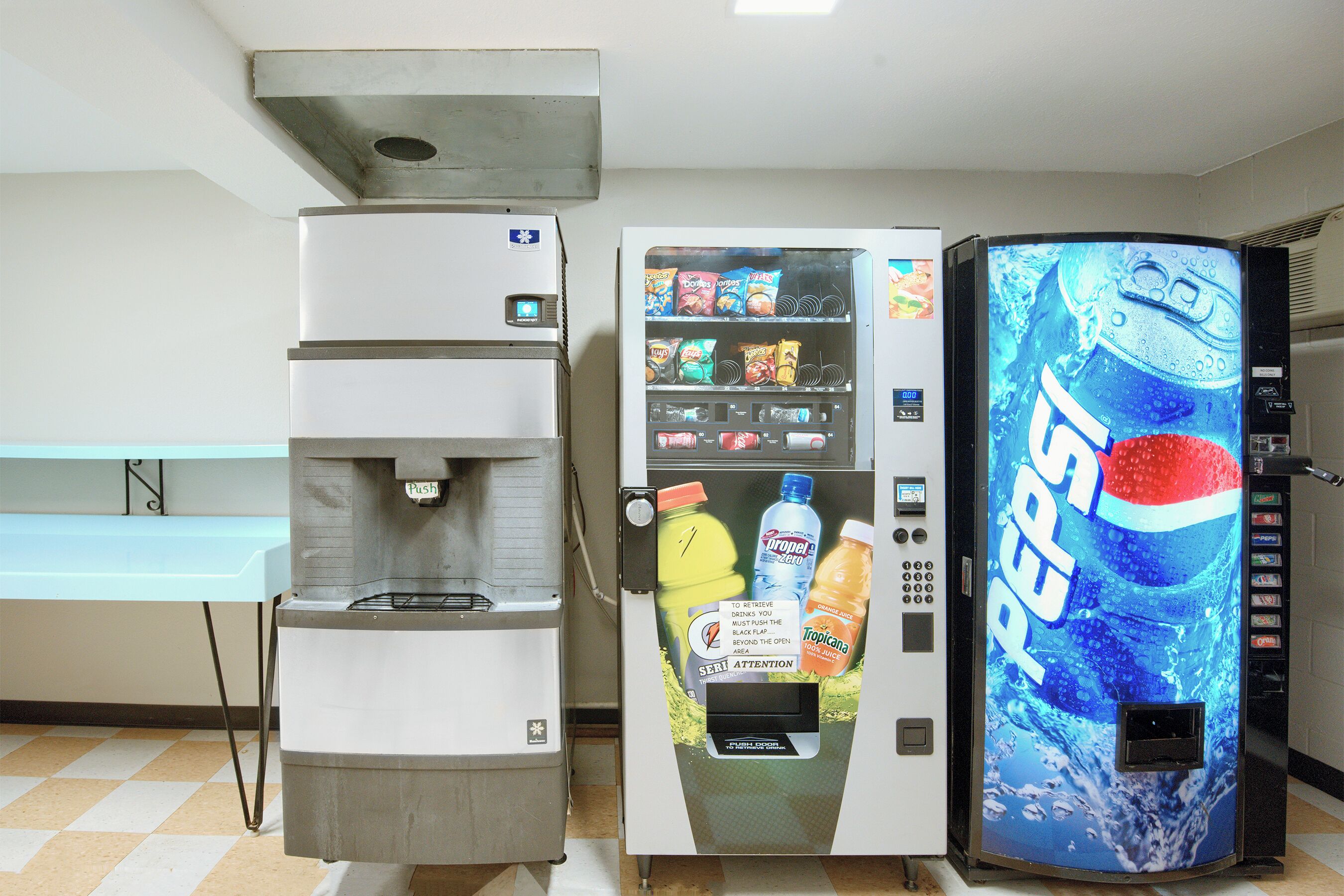 A vending machine with a Pepsi logo, a water dispenser, and a coffee machine.