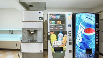 Una máquina expendedora con el logotipo de Pepsi, un dispensador de agua y una máquina de café.