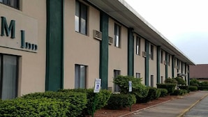 A W.M.I. Inn building with a row of windows and a parking sign. - Woonsocket Motor Inn (Woonsocket)