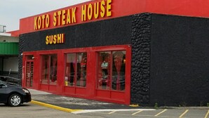 A building with a red and black exterior, labeled "KOTO STEAK HOUSE" and "SUSHI" on the signage. - Woonsocket Motor Inn (Woonsocket)