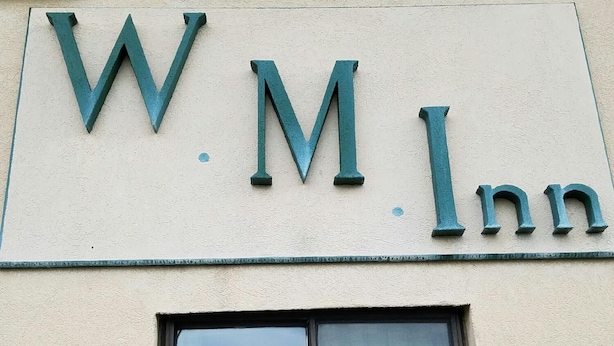 A building sign with the letters "W.M.Inn" indicating the name of the establishment. - Woonsocket Motor Inn (Woonsocket)