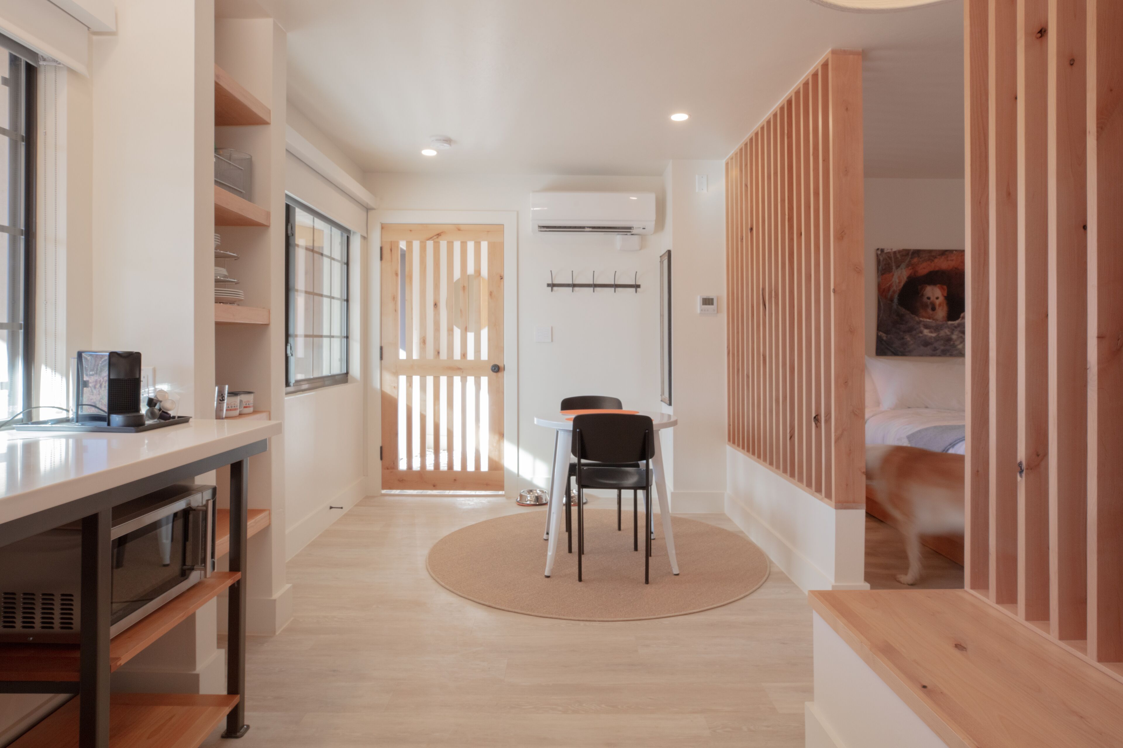 Een moderne keuken met een eethoek, een houten deur en een ruimte waar huisdieren welkom zijn.