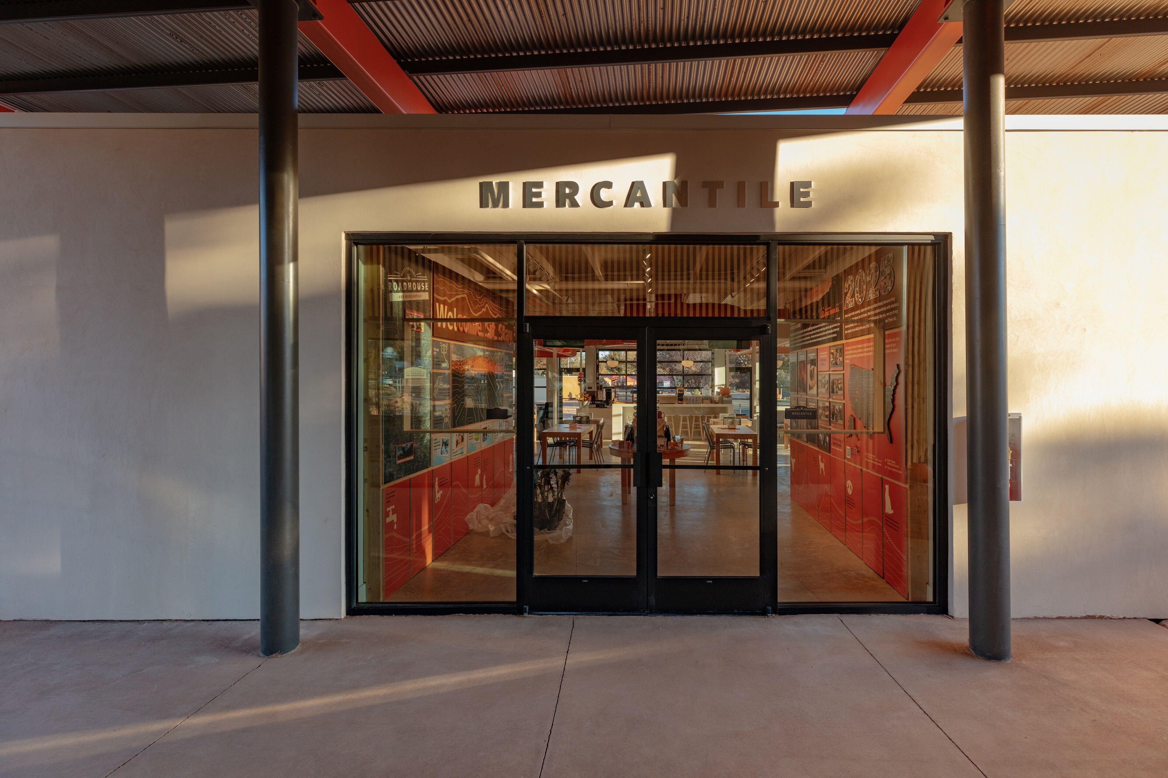 L’extérieur d’un magasin Mercantile, doté d’une architecture moderne, se caractérise par de grandes portes vitrées et un intérieur visible à travers ces vitres.
