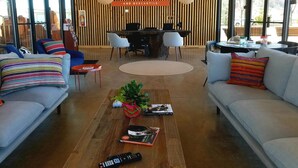 A modern interior with a reception desk, seating area, and large windows. - Best Friends Roadhouse and Mercantile (Kanab)