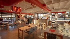 A spacious café with multiple seating areas, large windows, and a modern interior design. - Best Friends Roadhouse and Mercantile (Kanab)