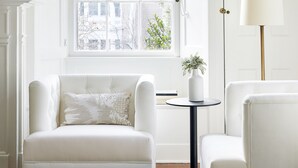A room with a white sofa, a small round table, and a lamp. - Kennebunkport Captains Collection (Kennebunkport)