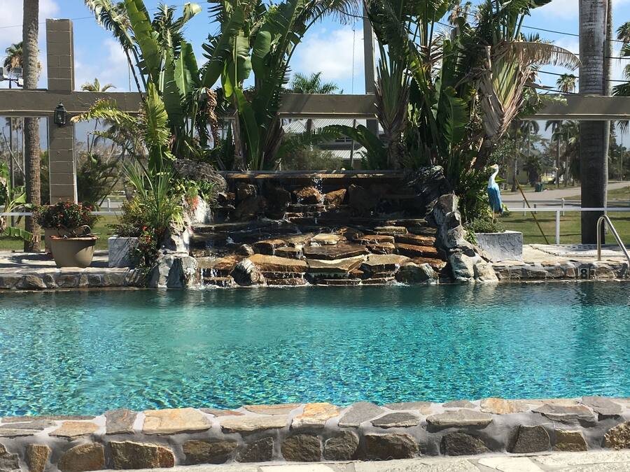 Een buitenzwembad, parasols voor strand/zwembad