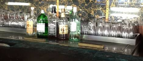 A bar area with shelves of glasses and bottles of liquor.