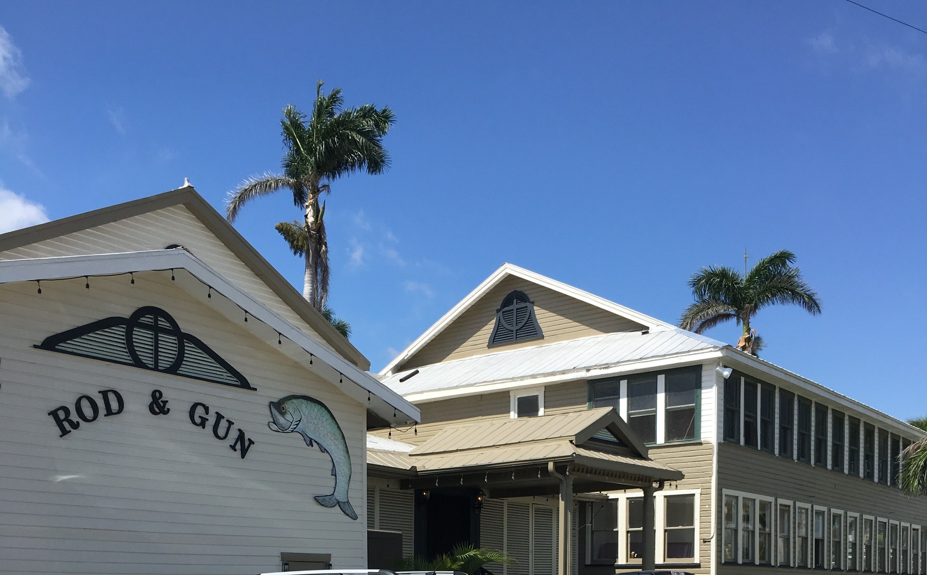 A building with a sign reading "ROD & GUN" and a fish mural.