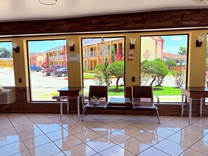 A hotel lobby with large windows, a tiled floor, and seating areas. - Great Western Inn Pasadena (Pasadena)