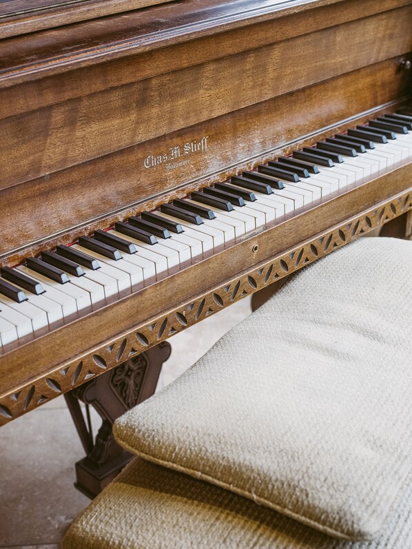 A grand piano with a wooden finish and the inscription "Chas. M. Steiff Baltimore." - Enzian Inn (Leavenworth)