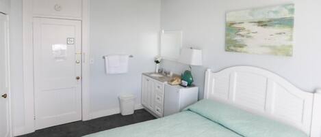 Un dormitorio con cama, cómoda y puerta.