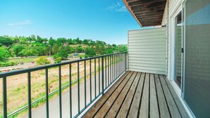 A balcony with a view of a green landscape and a road. - Pullman Garden Inn (Pullman)