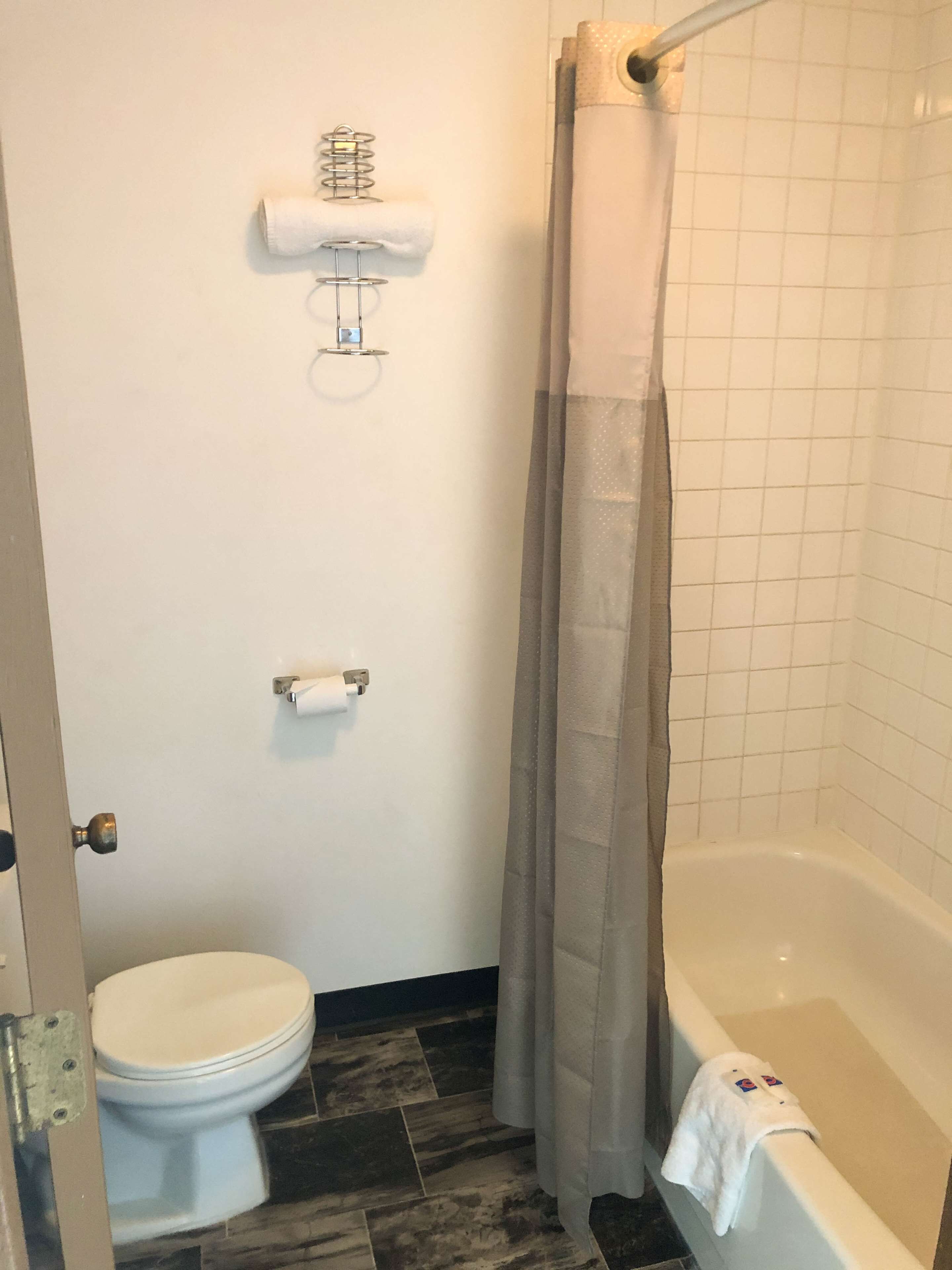 Ein Badezimmer mit Toilette, Duschvorhang und Badewanne.