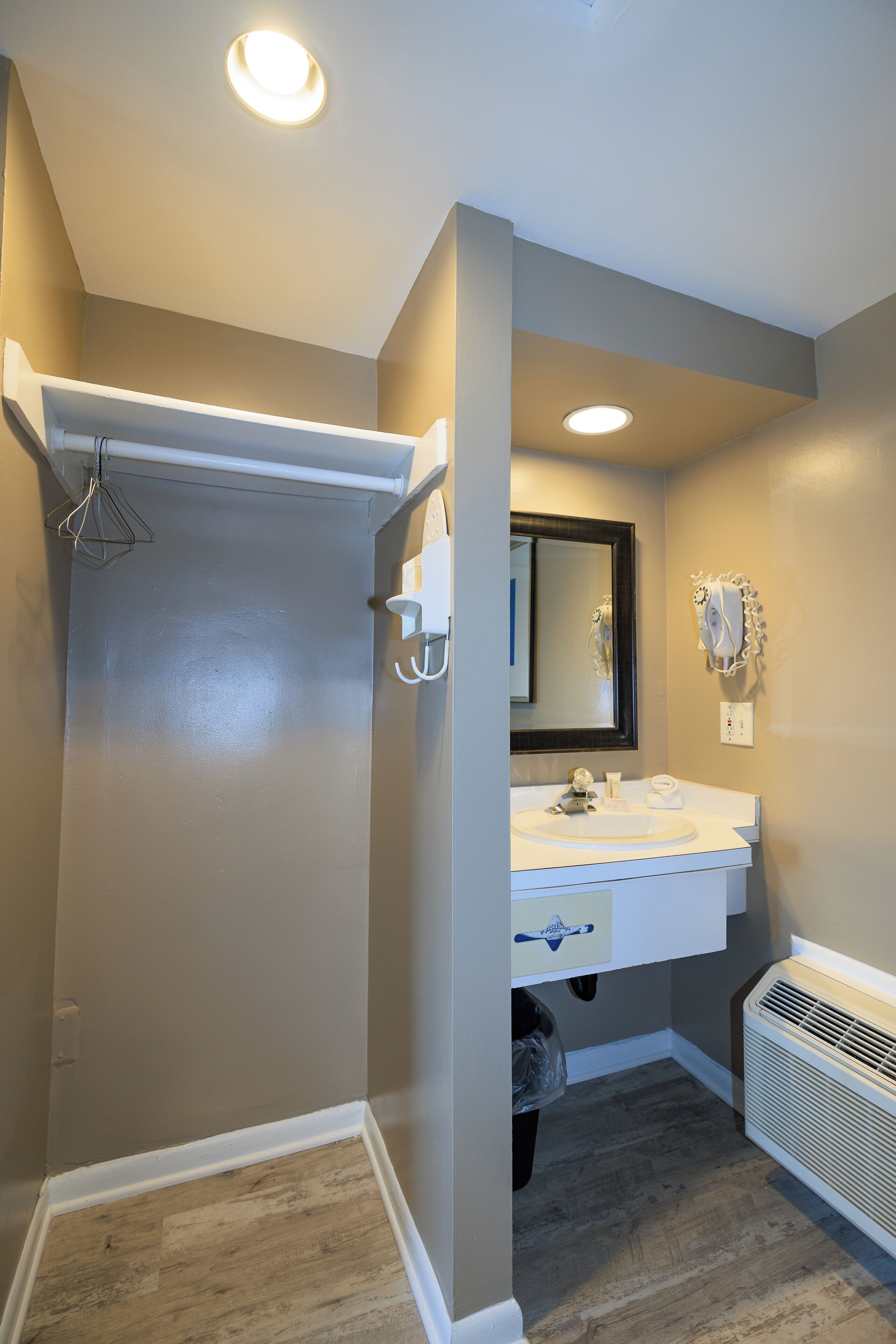Une salle de bain avec un meuble-lavabo blanc, un miroir et un espace douche.