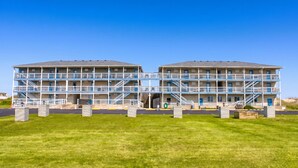A two-story building with a flat roof, multiple balconies, and a central entrance. - Blue Heron Motel (Nags Head)