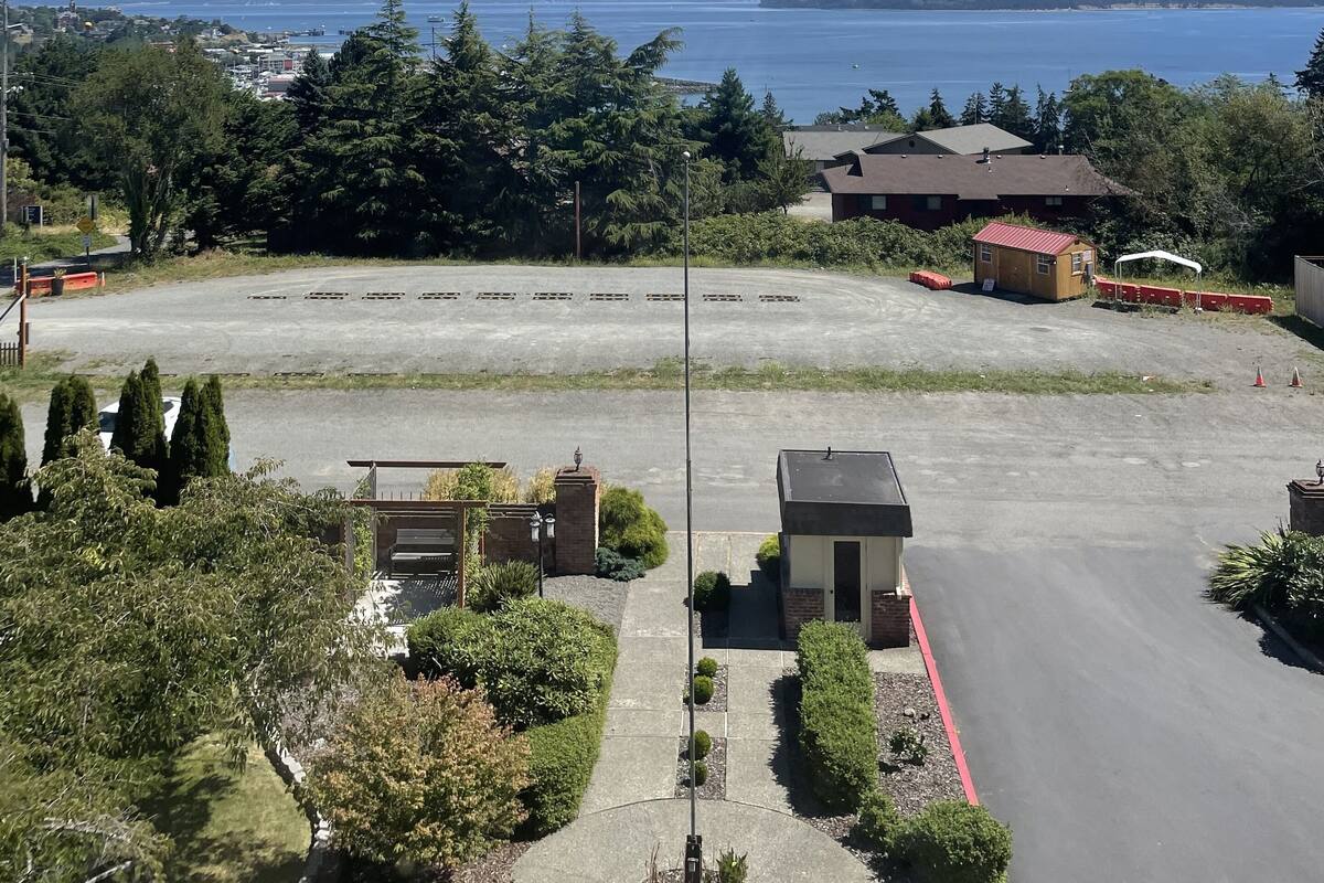 A parking lot with a view of a body of water and mountains in the distance.