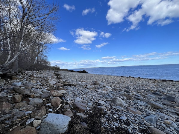 A rocky beach with a clear sky and calm sea.