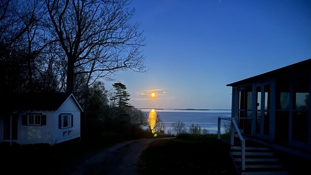 A coastal house with a view of the sunset over the water. - High Tide Inn (Camden)