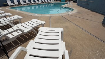 Una piscina al aire libre de temporada, sombrillas