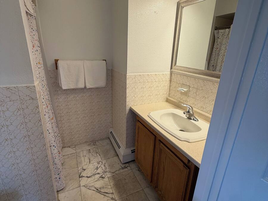A bathroom with a toilet, sink, and shower area.