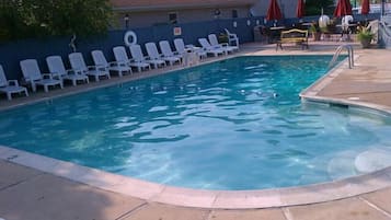 Una piscina al aire libre de temporada, sombrillas