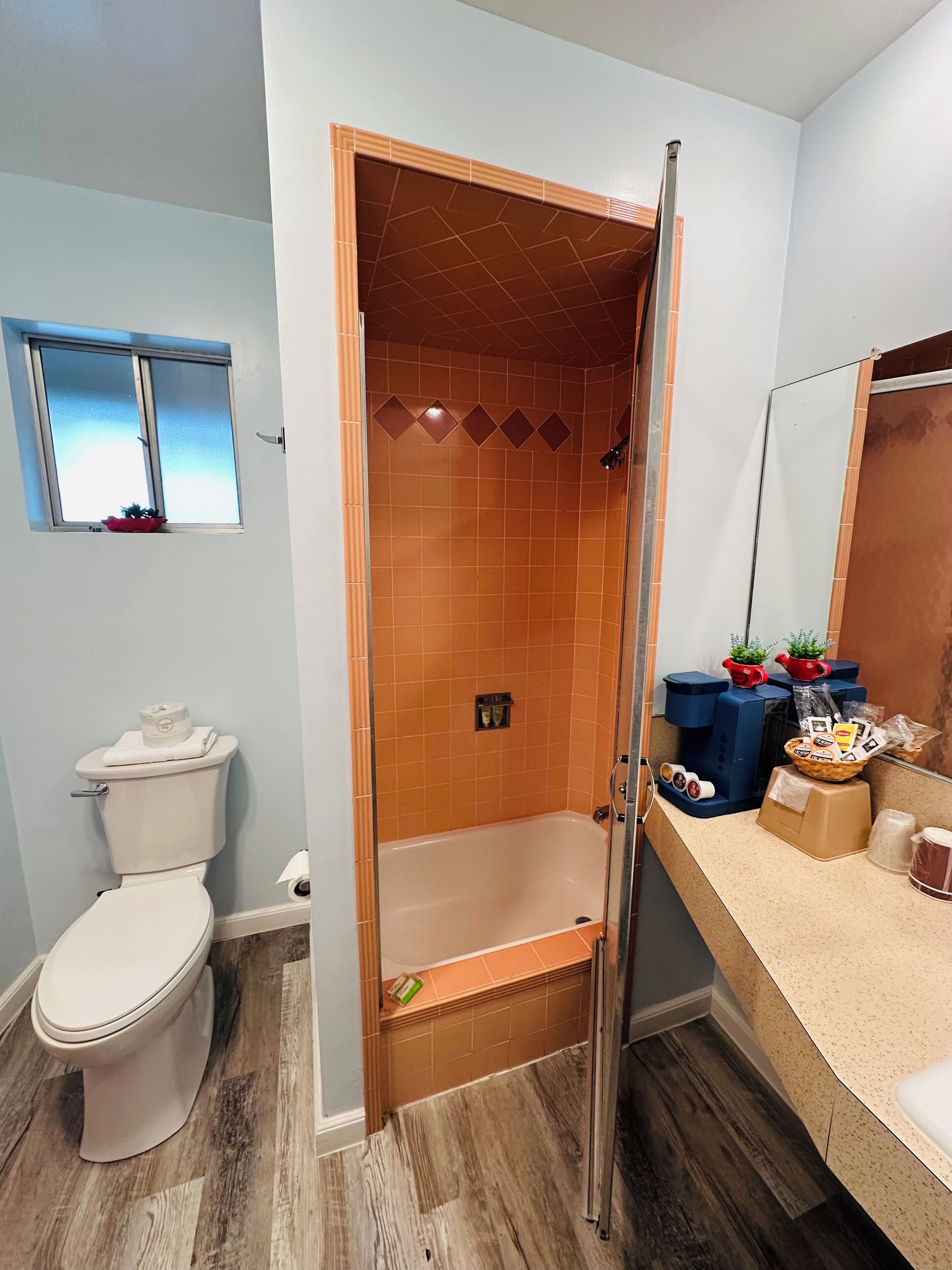 A bathroom with a shower, toilet, and sink.