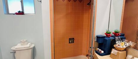 A bathroom with a shower, toilet, and sink.