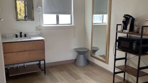 Un baño con tocador de madera, inodoro y un espejo grande.