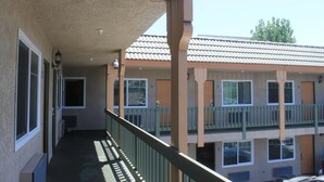A building with multiple balconies, a covered walkway, and a tiled roof. - El Rancho Inn Hawthorne (Hawthorne)