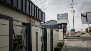 A Pacific Inn building with a sign indicating a business district. - Pacific Inn (Crescent City)