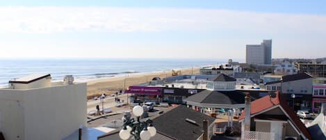 A coastal town with buildings, a beach, and a clear sky.
