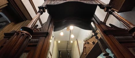 A wooden staircase with ornate balustrades and a chandelier.