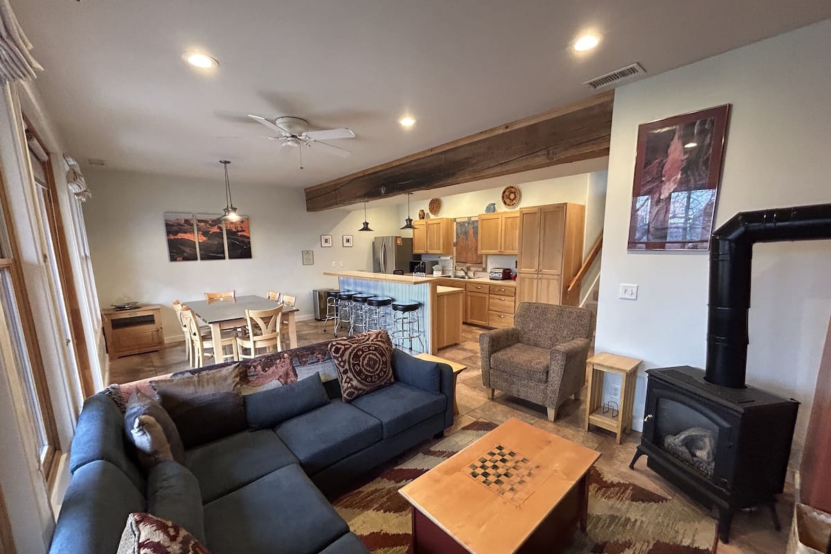 A modern living room with a sectional sofa, a coffee table, and a fireplace.