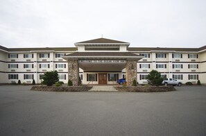 A multi-story hotel with a welcoming entrance, a sign reading "Welcome to the Ocean View Inn," and a parking lot with a few cars. - Oceanview Inn (Crescent City)