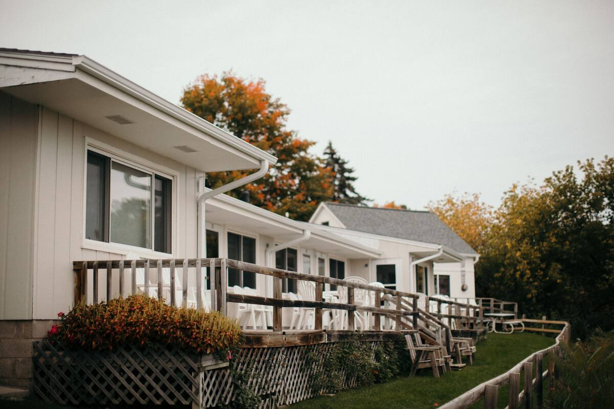 A row of white cabins with wooden railings and steps leading to the entrance.