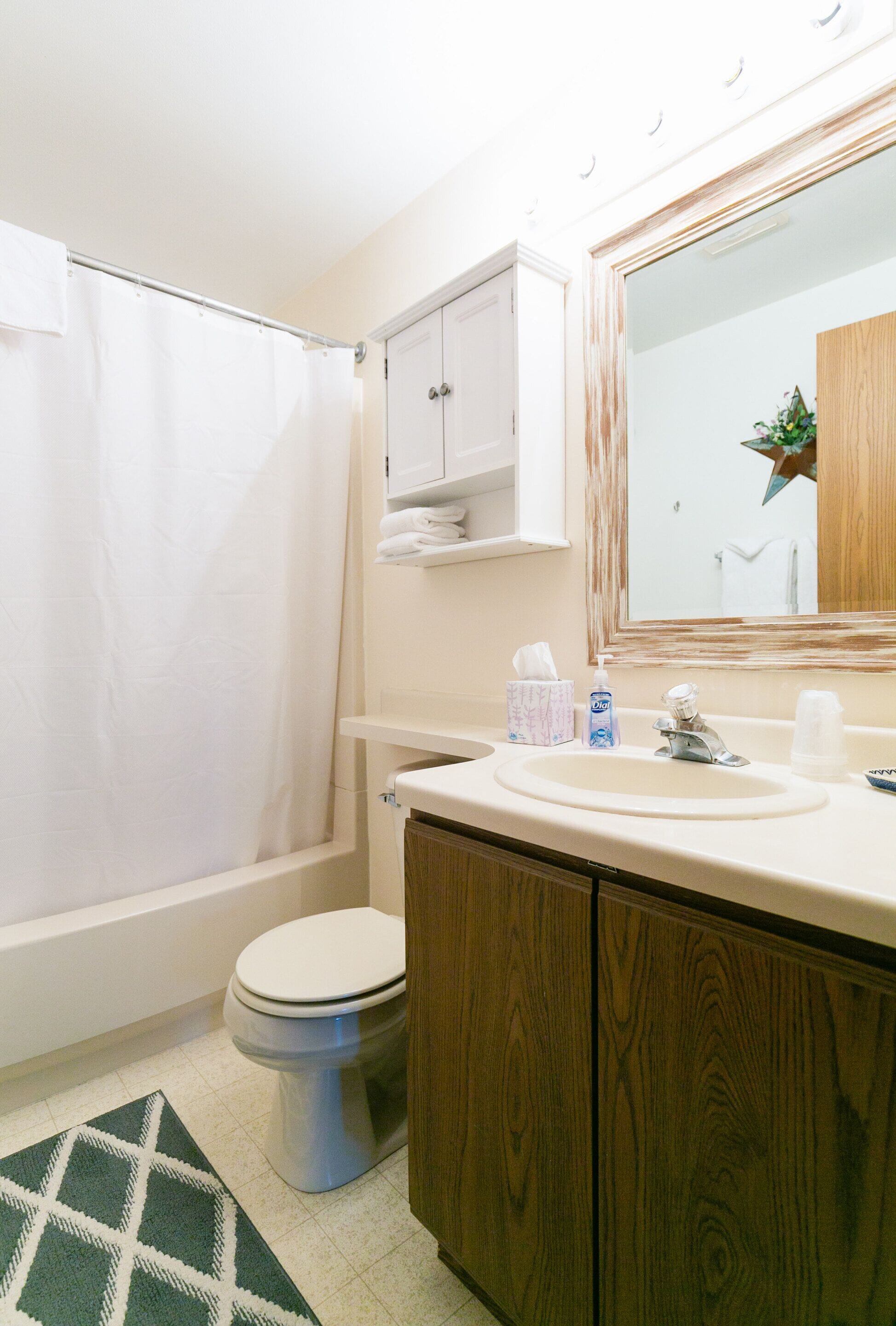 A bathroom with a toilet, sink, and shower curtain.
