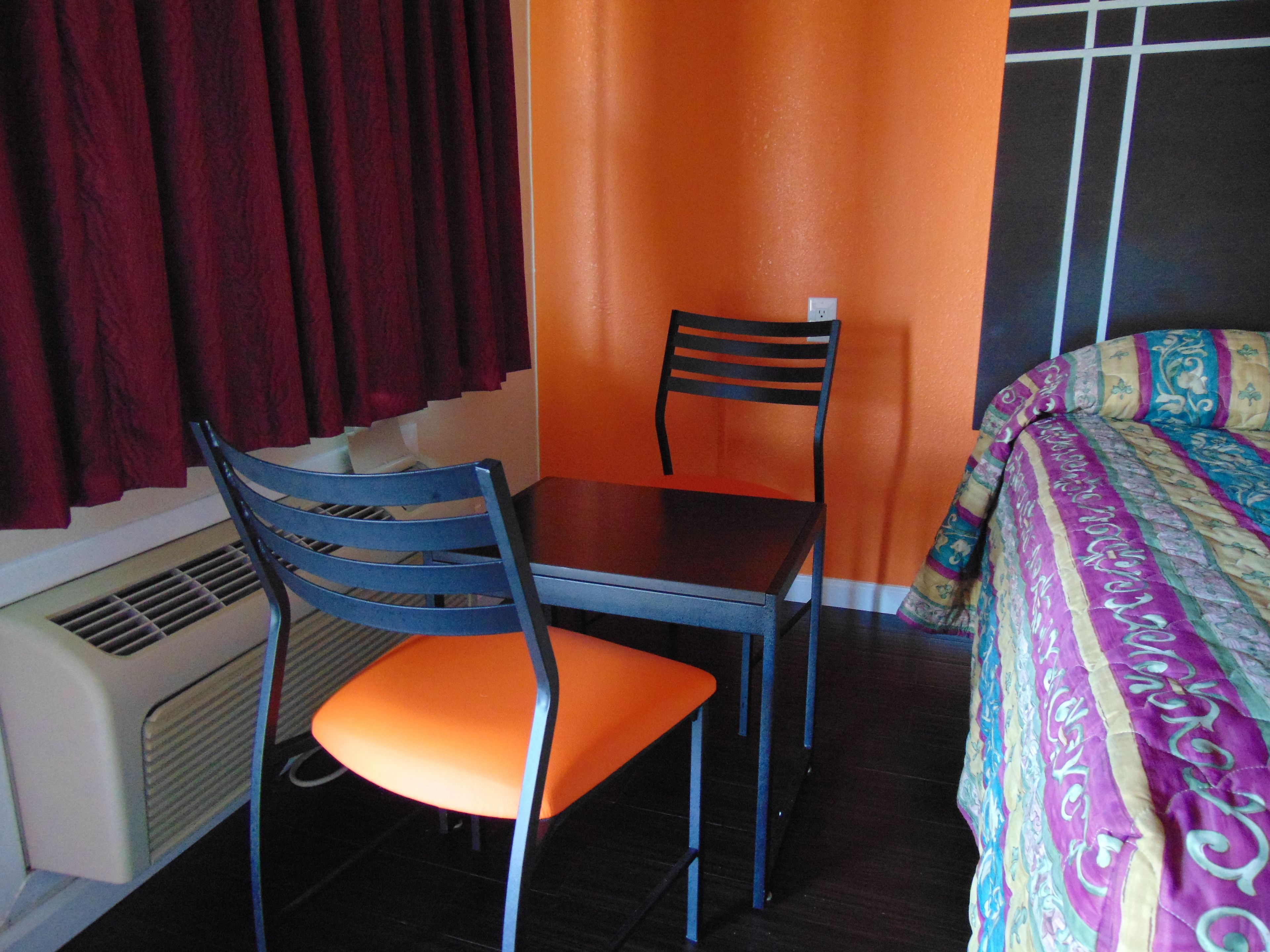 A room with a bed, a table, and a chair.