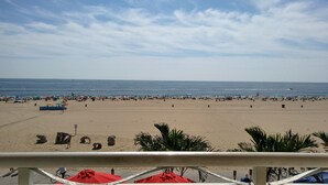 Een strand met parasols en mensen.