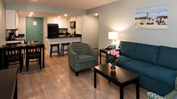 A compact living space with a kitchenette, a dining area, a sofa, and a coffee table.