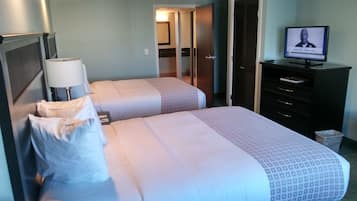 A hotel room with two beds, a desk, a television, and a wardrobe.