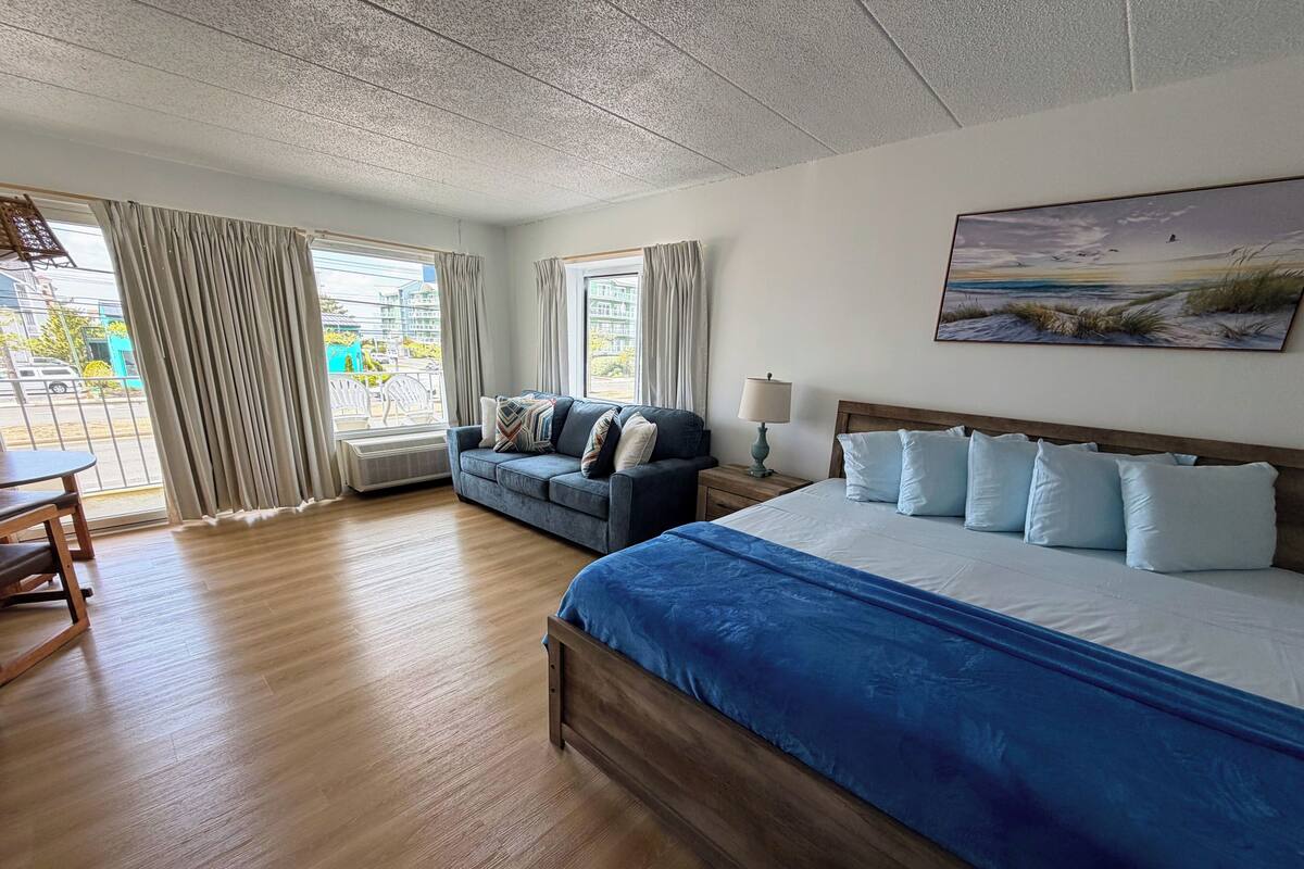 Ein Hotelzimmer mit Bett, Sofa, Tisch und einem Bild an der Wand.