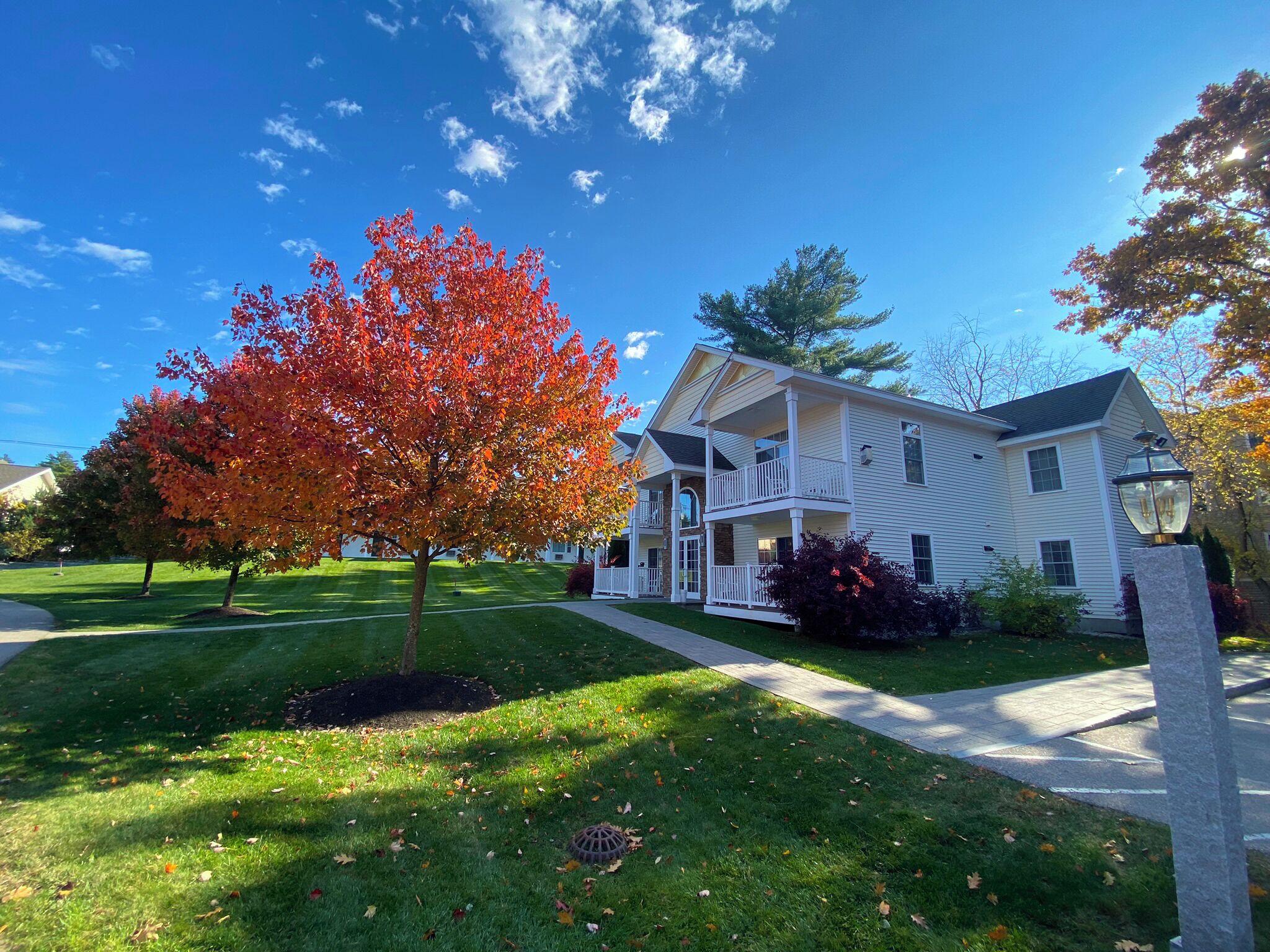 A two-story house with a front porch and a driveway leading to the entrance.