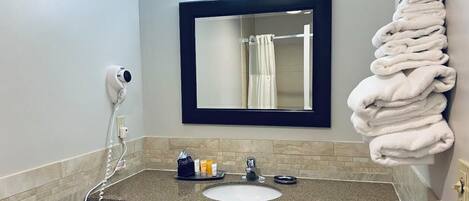 A bathroom with a sink, mirror, and towel rack.