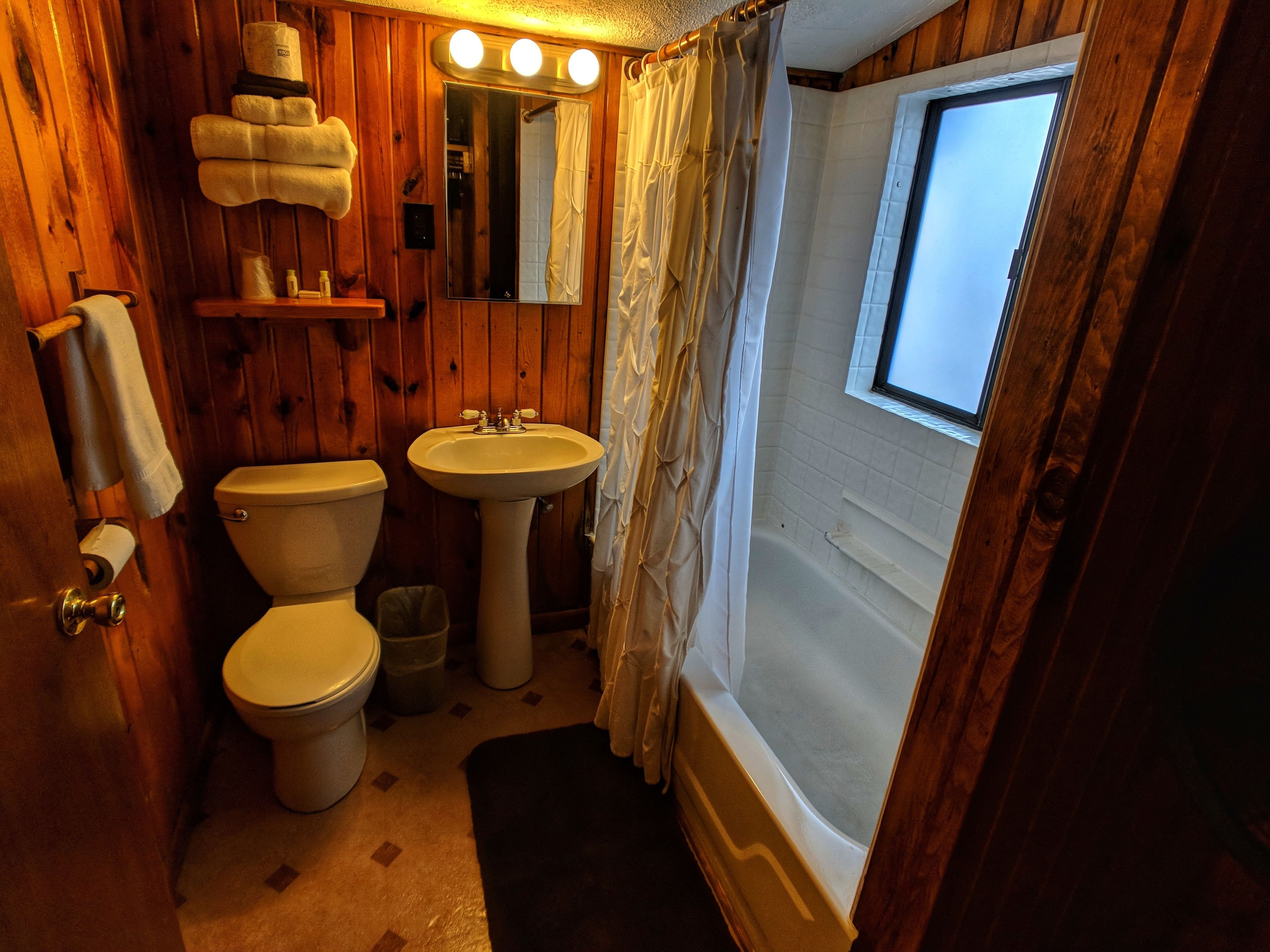 Puinen kylpyhuone, jossa on wc, pesuallas ja kylpyamme.