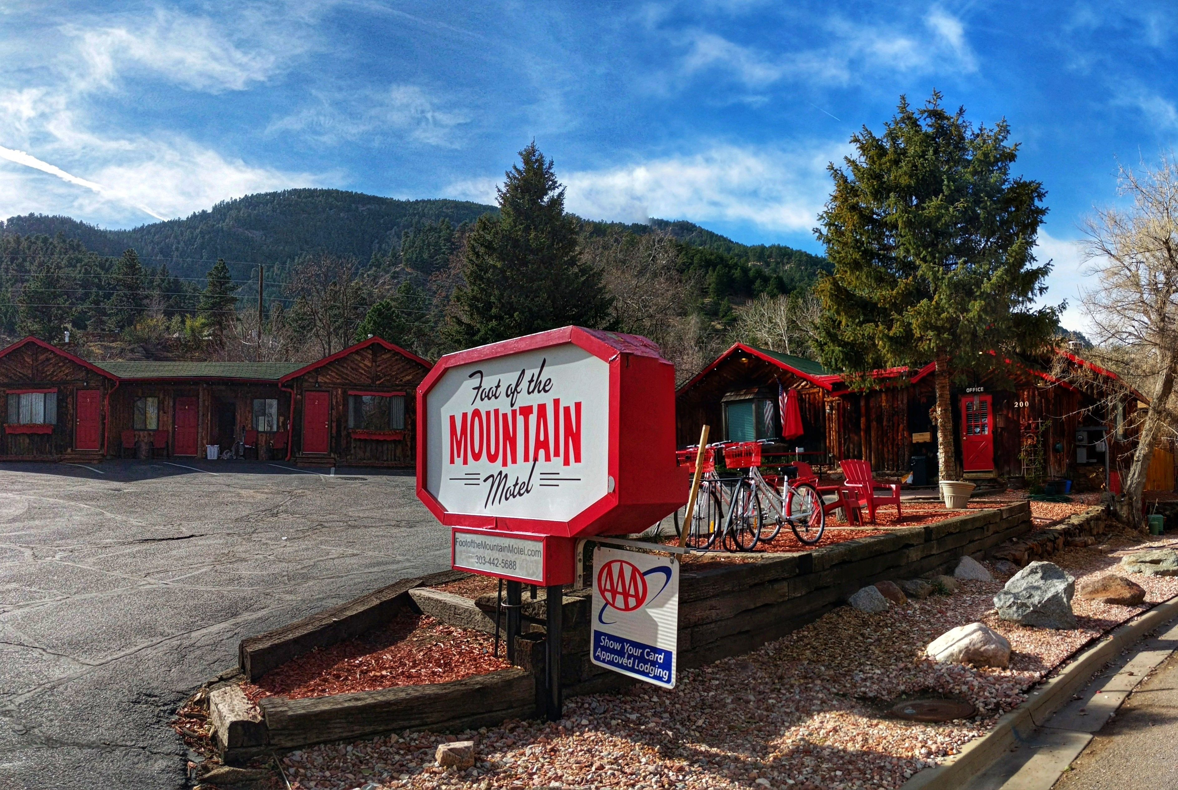 A motel sign with a mountain view, outdoor seating, and bicycles.