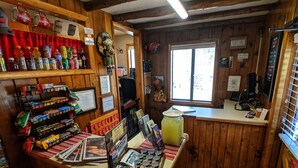 A rustic interior with wooden walls, a reception desk, various snacks, and a large window. - Foot of the Mountain Motel (Boulder)