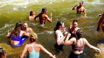 A group of people in a river, some in water and others on inflatable rafts.