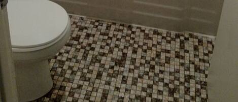 A bathroom with a bathtub, toilet, and a shower curtain.