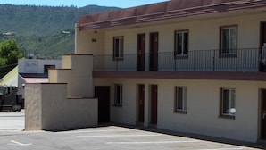 A two-story building with a parking lot in front. - Budget INN (Durango)